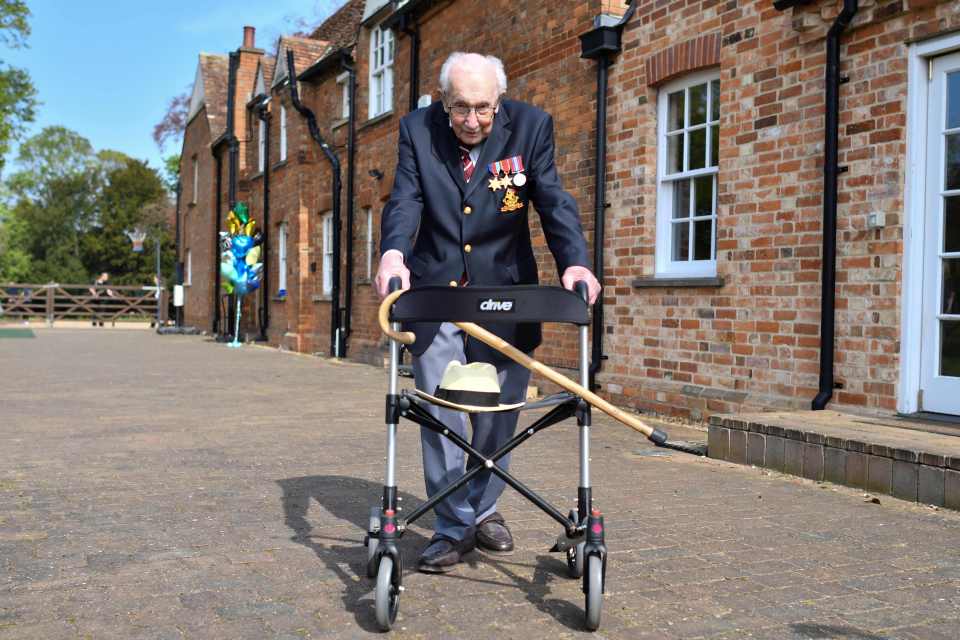 WWII veteran Captain Tom Moore using a walking frame in his garden.