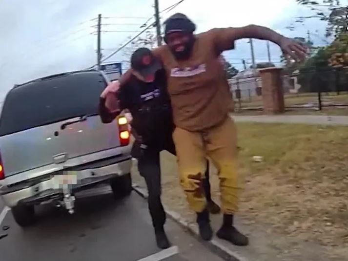 Police officer arresting a man who has a gun.