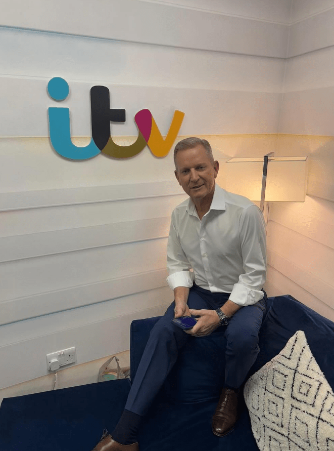 Man sitting on a couch in front of an ITV logo.