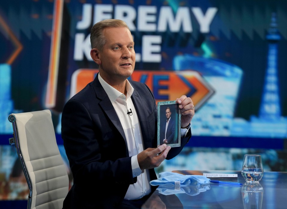 Jeremy Kyle holding a framed portrait on his TalkTV show.