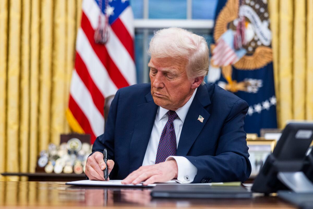 President Trump signs executive orders in the Oval Office. 