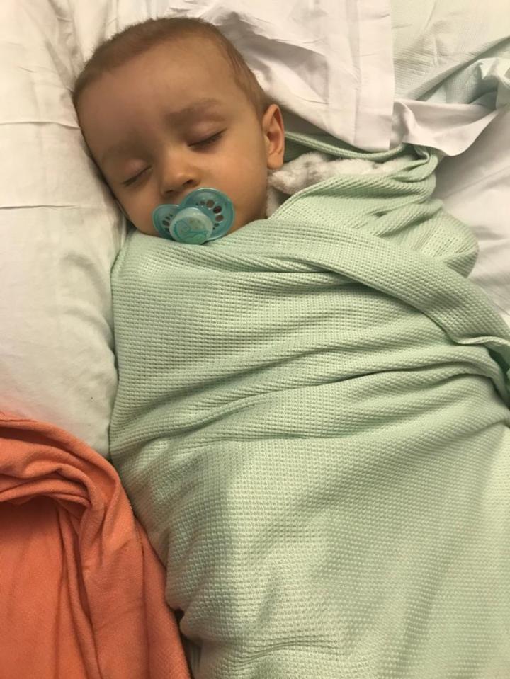 Toddler sleeping in a mint green blanket.