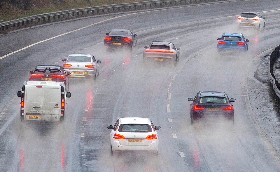 Cars driving on a motorway in heavy rain.