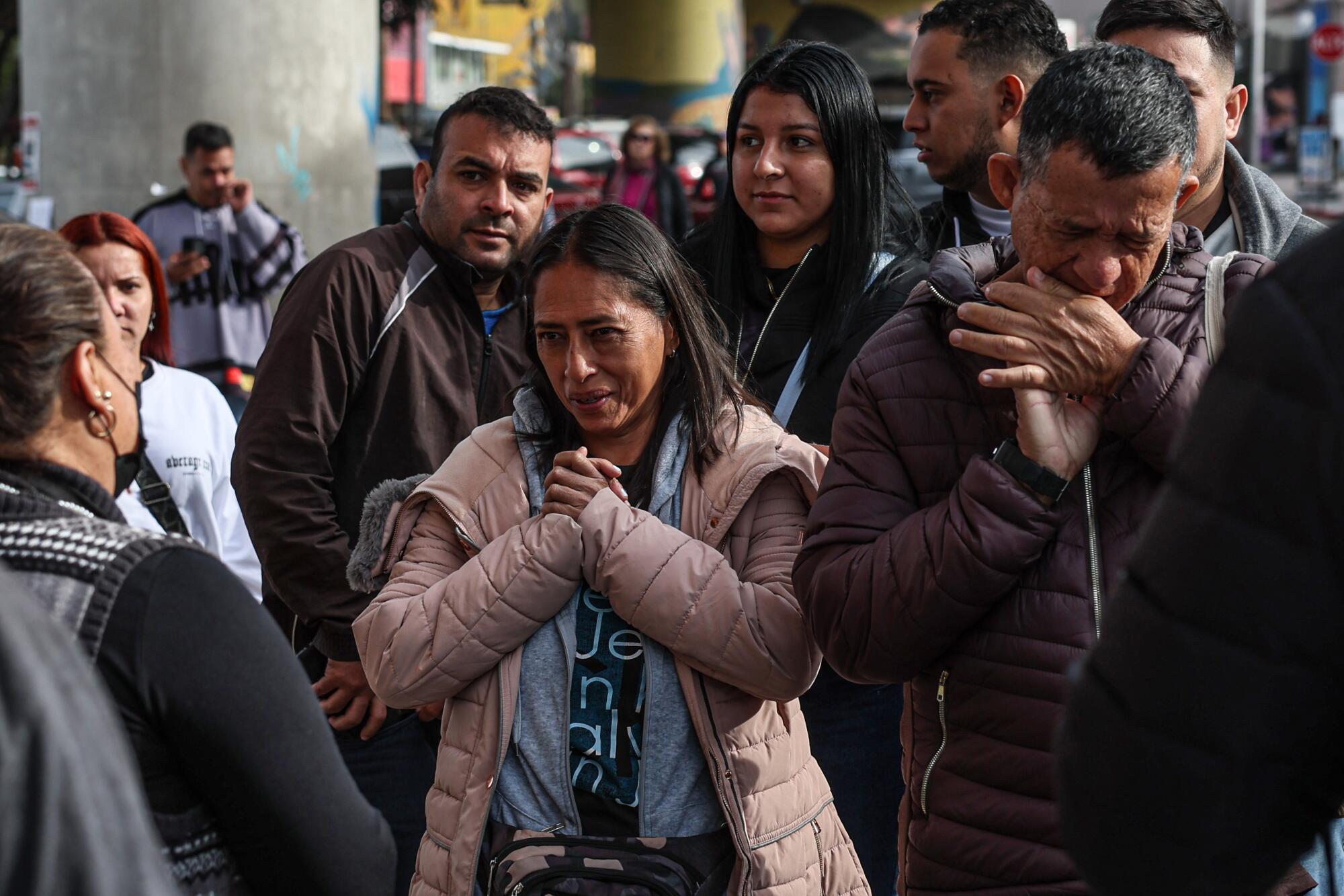 A migrant woman and her husband cry as aid workers deliver breakfast for the dozens of asylum seekers.