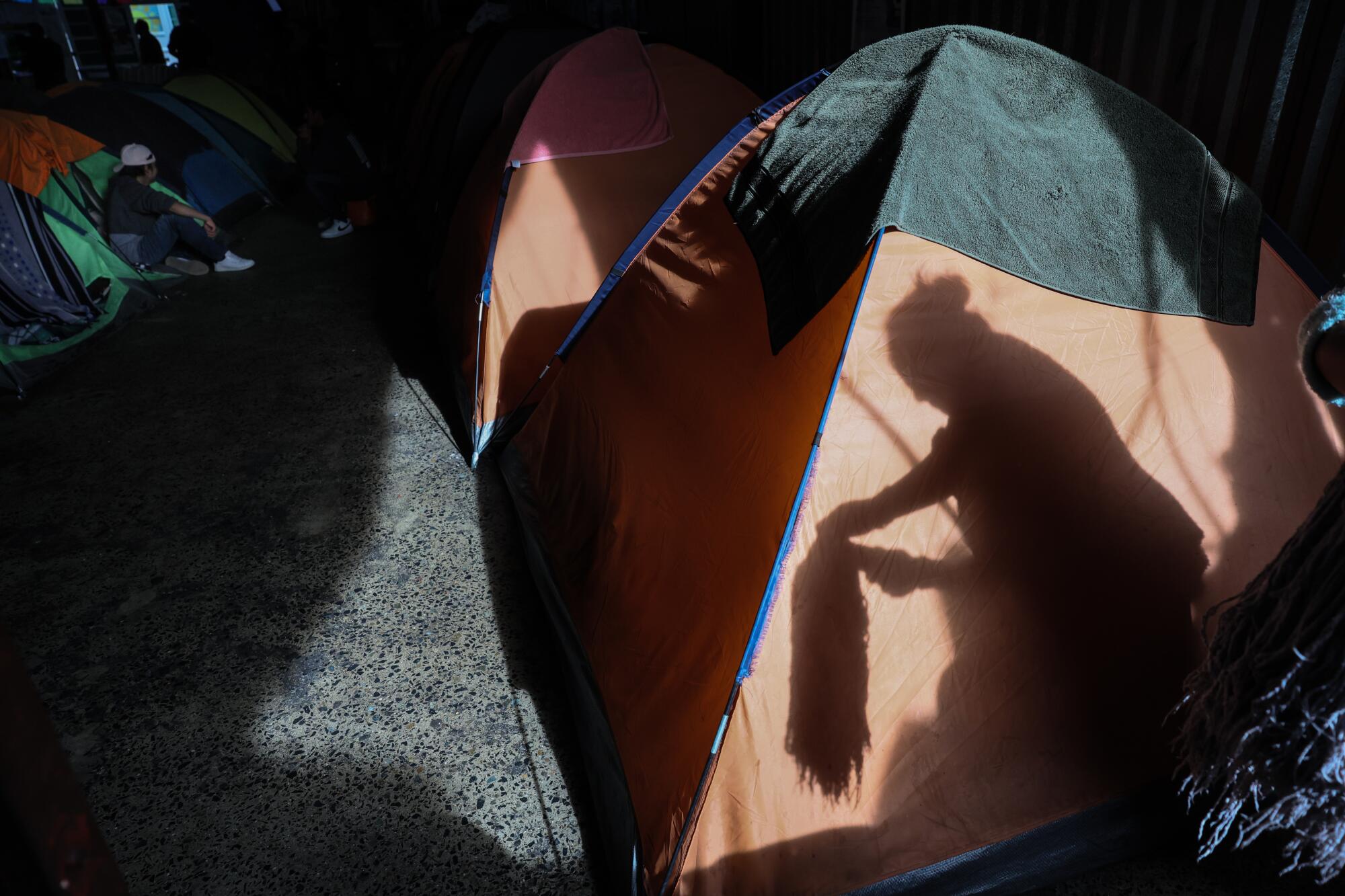 A woman's shadow is seen reflected on a camping tent.