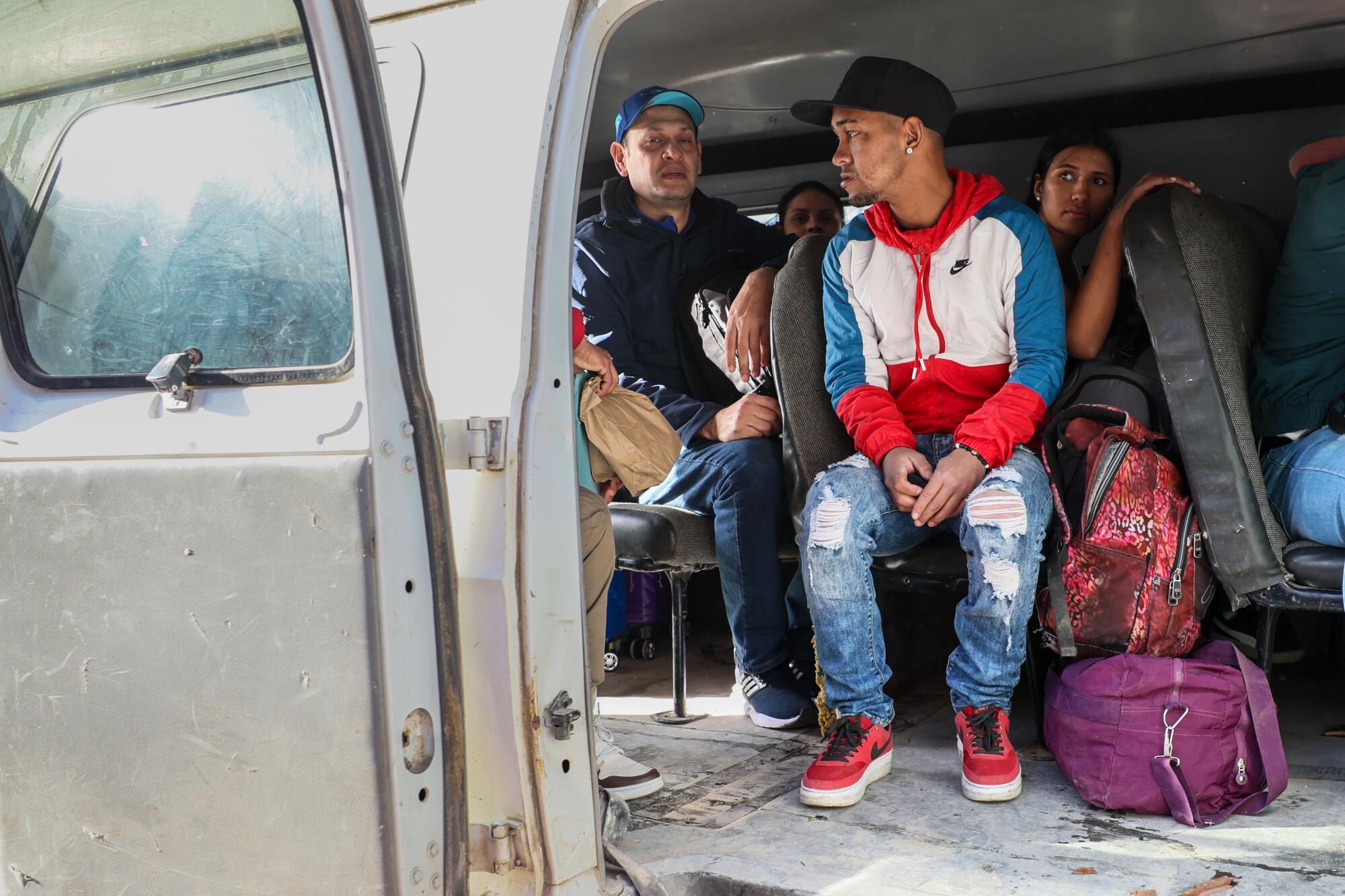 Asylum seekers board a van for transport to a shelter.