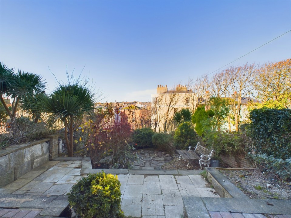 Garden of a five-bedroom house with a stone cave.