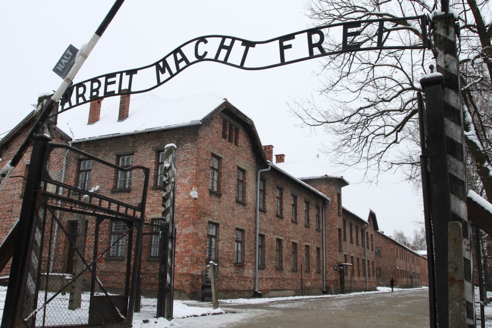 Auschwitz-Birkenau concentration camp gate with "Arbeit Macht Frei" sign.