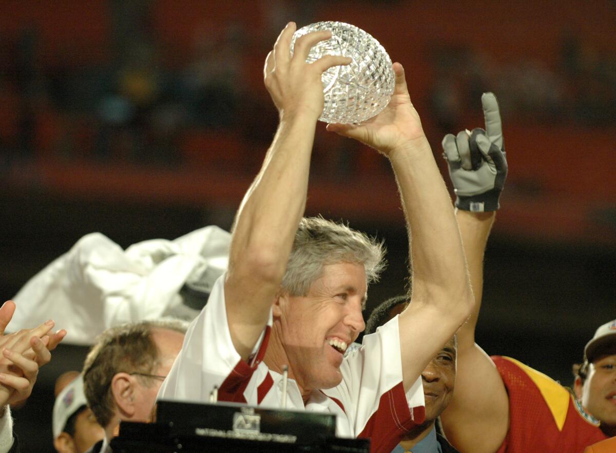 USC coach Pete Carroll holds up the National Championship Trophy after beating Oklahoma 55-19 in 2005.