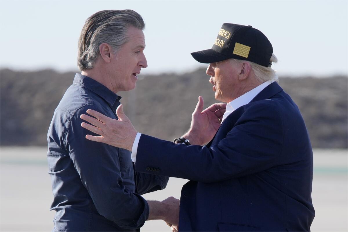 Governor Gavin Newsom, left, shakes hands with President Trump on a tarmac