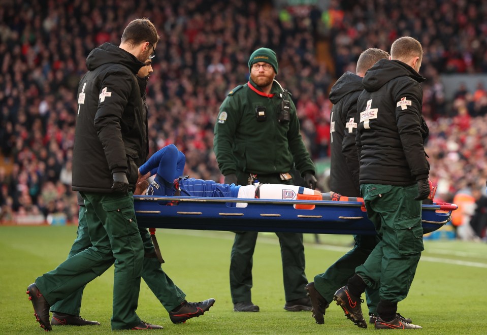 Injured soccer player being carried off the field on a stretcher.