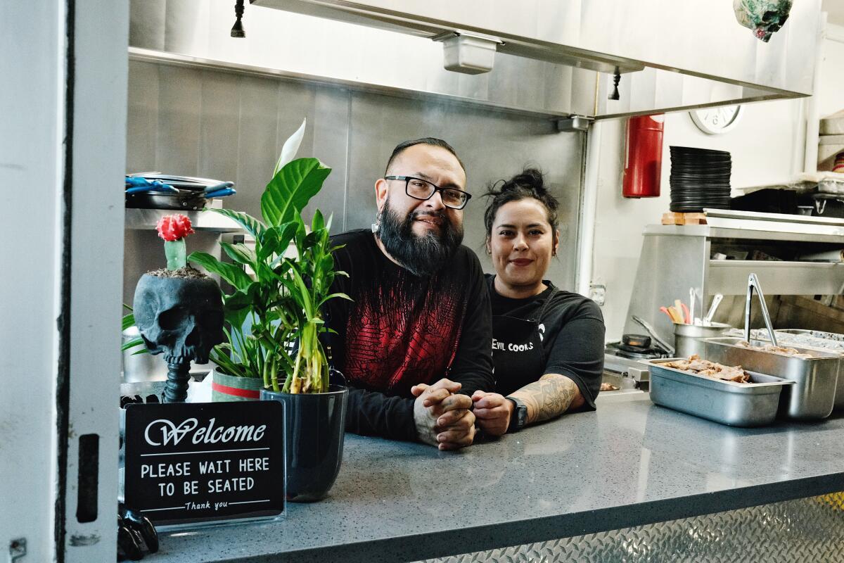 A man and woman stand in the kitchen of Evil Cooks in El Sereno