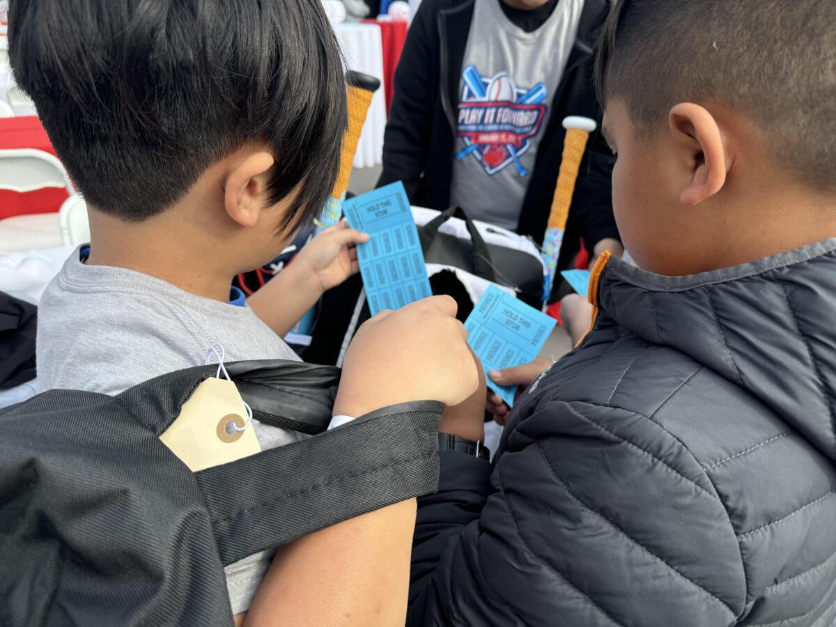 Players from Altadena Little League look at raffle tickets during an event sponsored by the Max Fried Foundation.