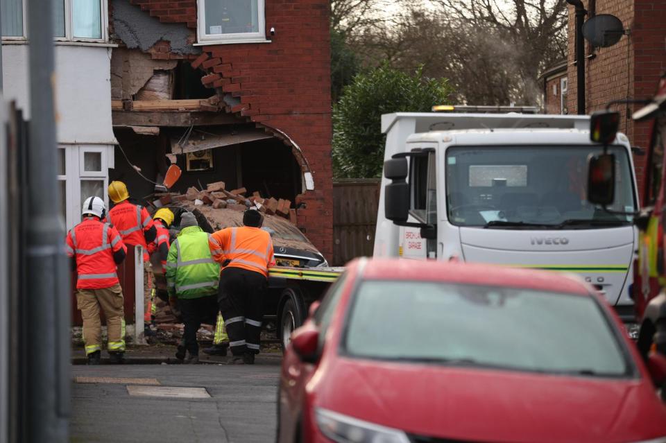 Car crashed into a house. Emergency personnel at the scene.