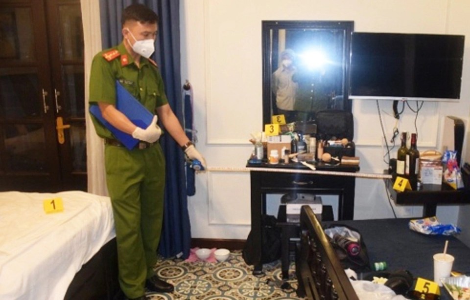 Police officer measuring a hotel room during a crime scene investigation.