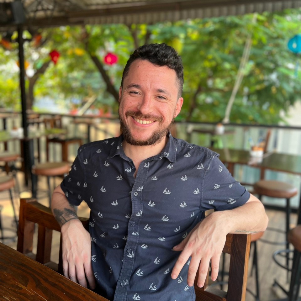 Man smiling at a patio table.