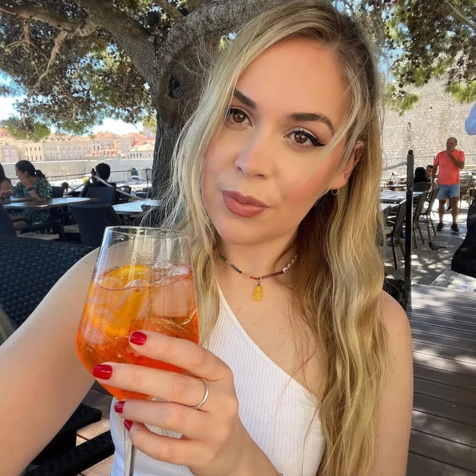 Woman holding an Aperol Spritz.