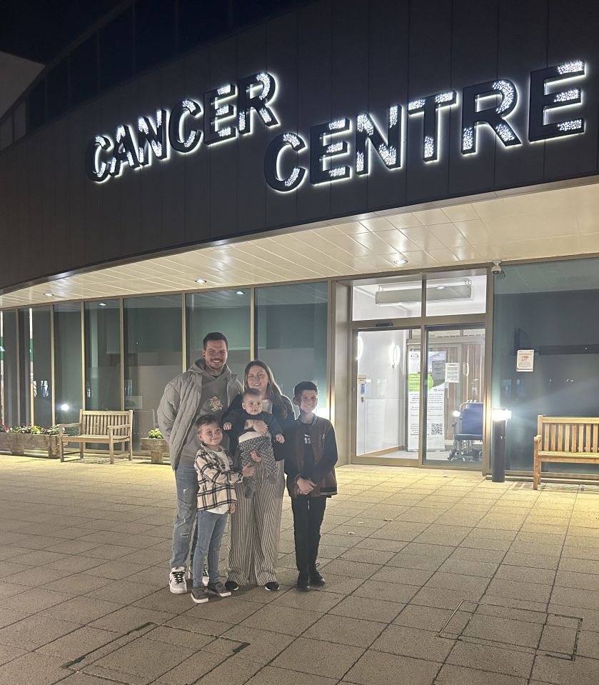 Family standing in front of a Cancer Centre.