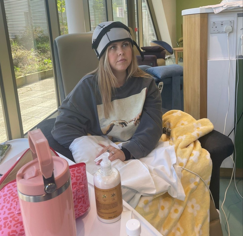 Woman in a hospital room wearing a cooling cap.