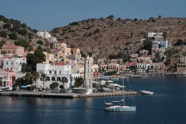 A view of the colourfully painted homes on the island and a yacht on the water