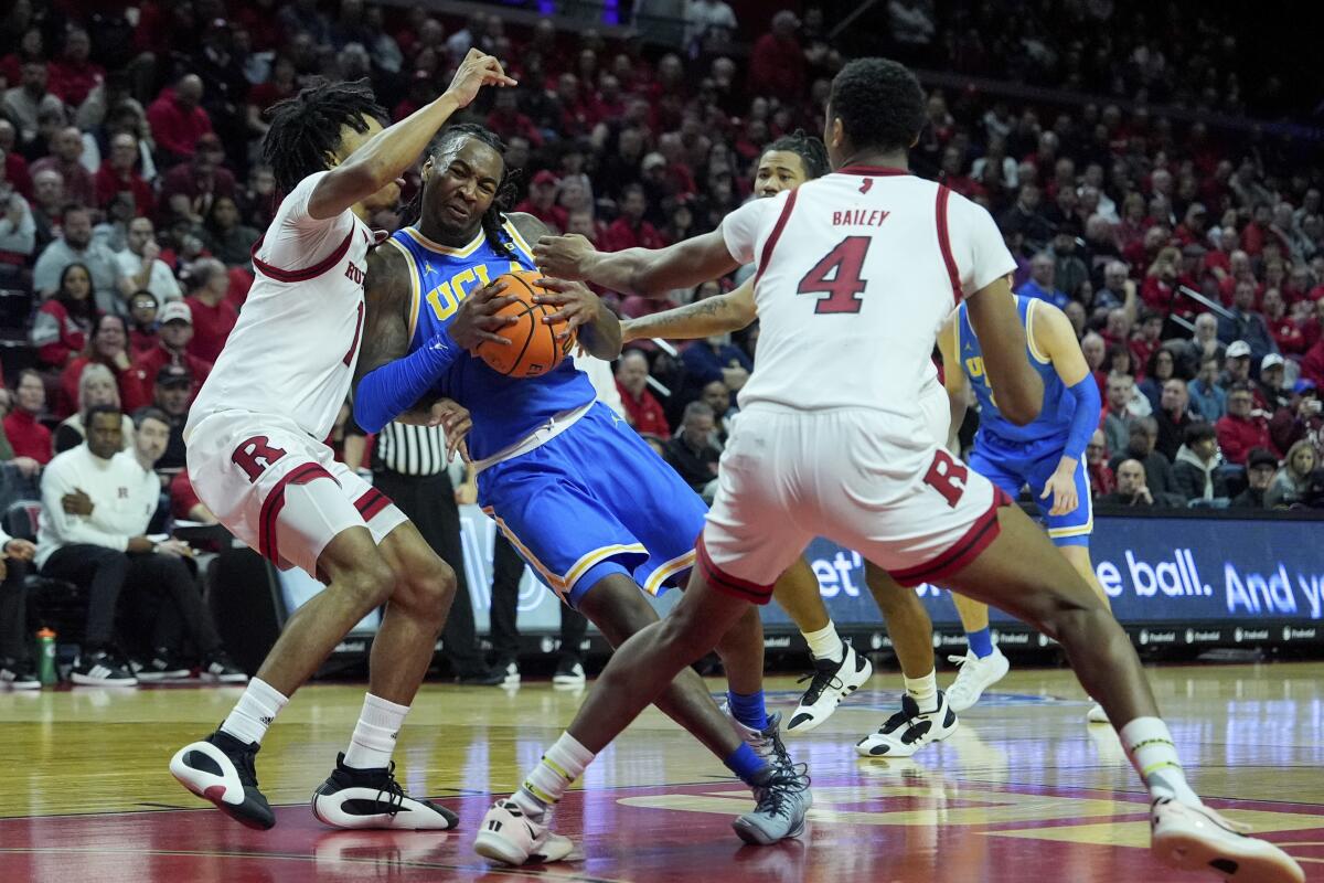 UCLA guard Sebastian Mack drives into Rutgers guard Jamichael Davis