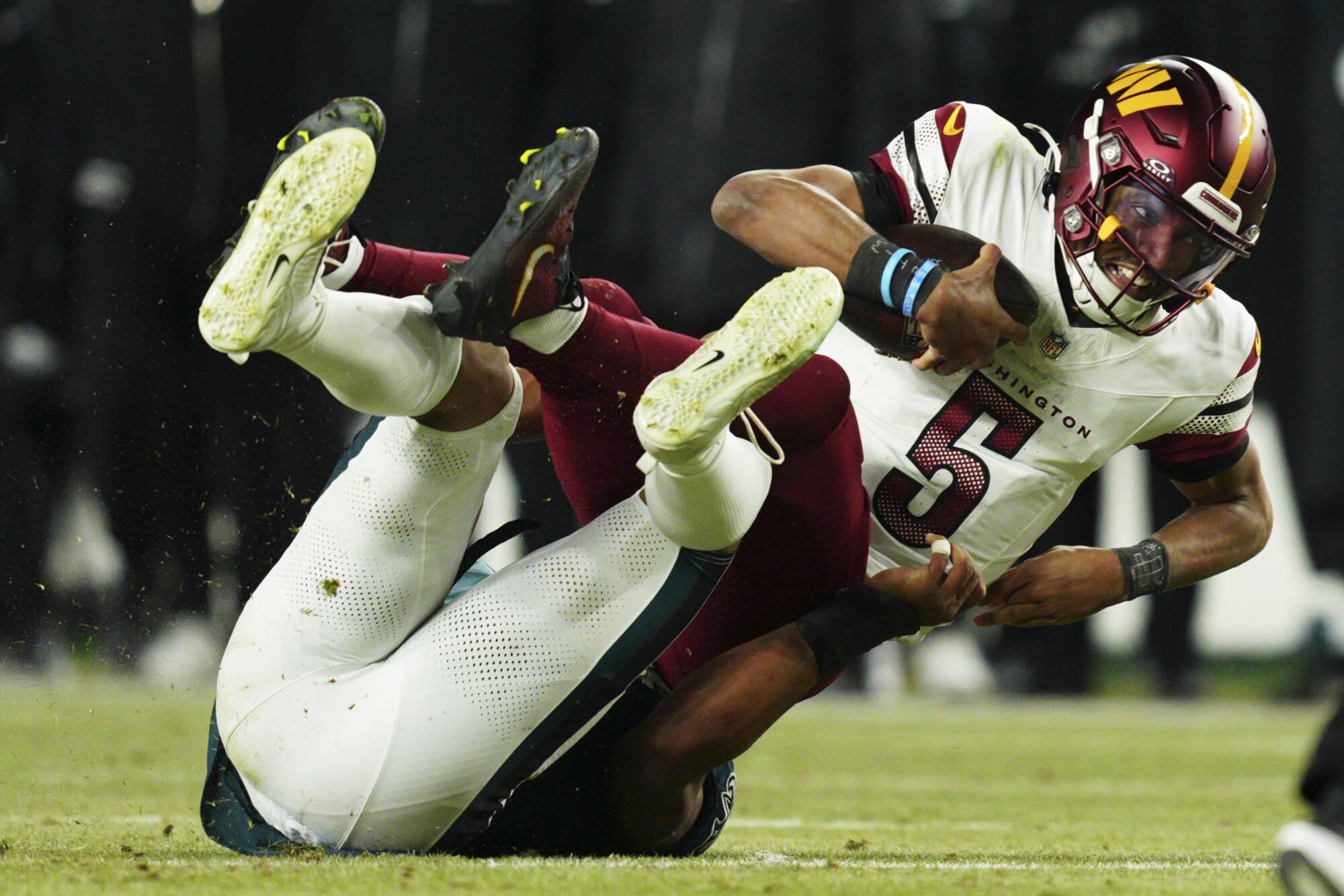 Washington Commanders quarterback Jayden Daniels is sacked by Philadelphia Eagles linebacker Nolan Smith.