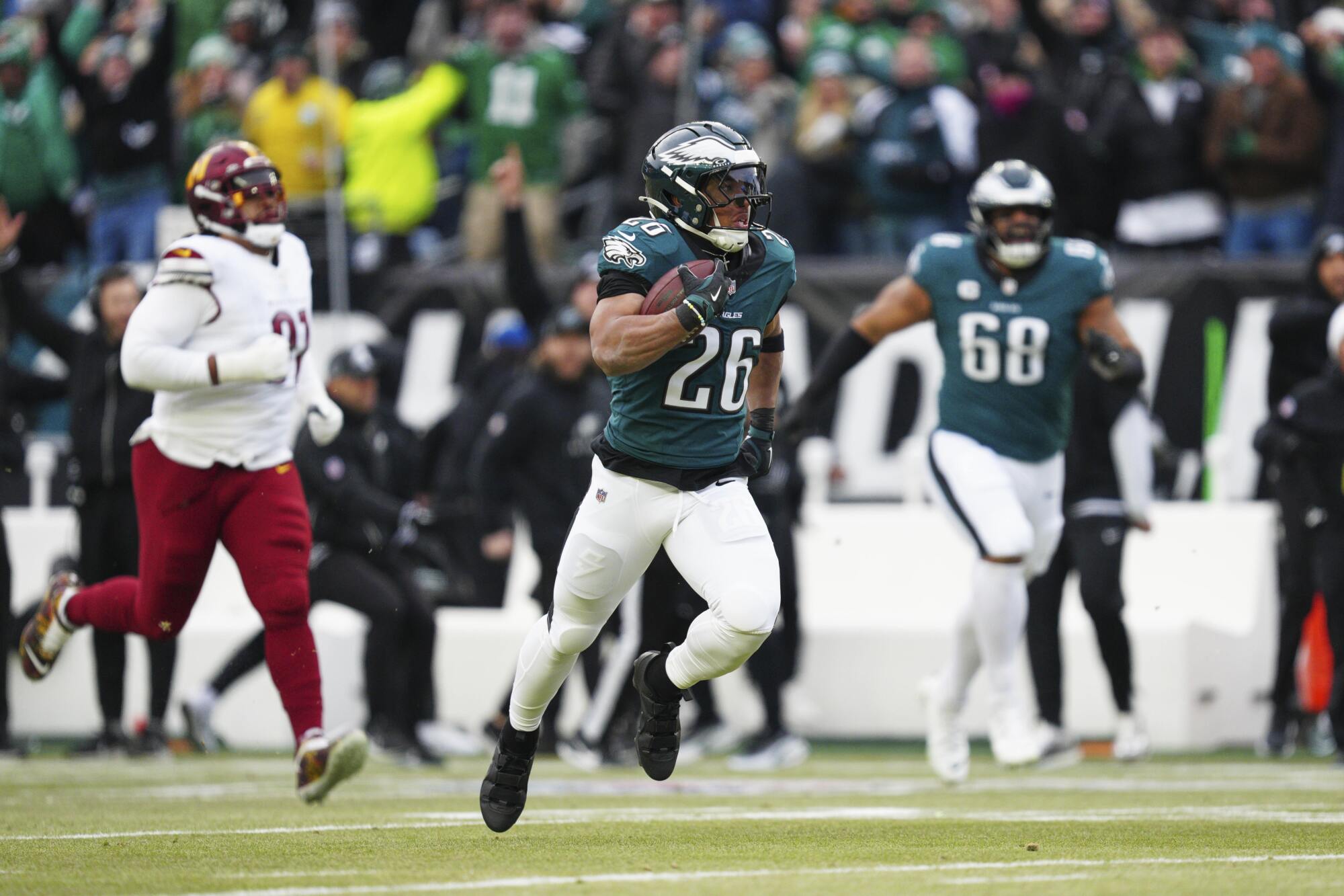 The Eagles' Saquon Barkley (26) runs for a touchdown against the Commanders in the NFC championship game.