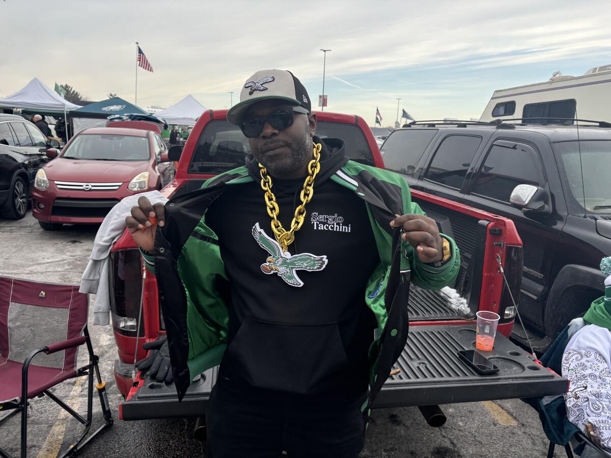 Eagles fan Ted Holloway shows off an Eagles necklace, jacket and hat at a tailgate.