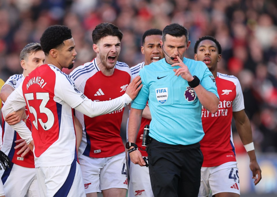 Arsenal players appealing to a referee after a red card.