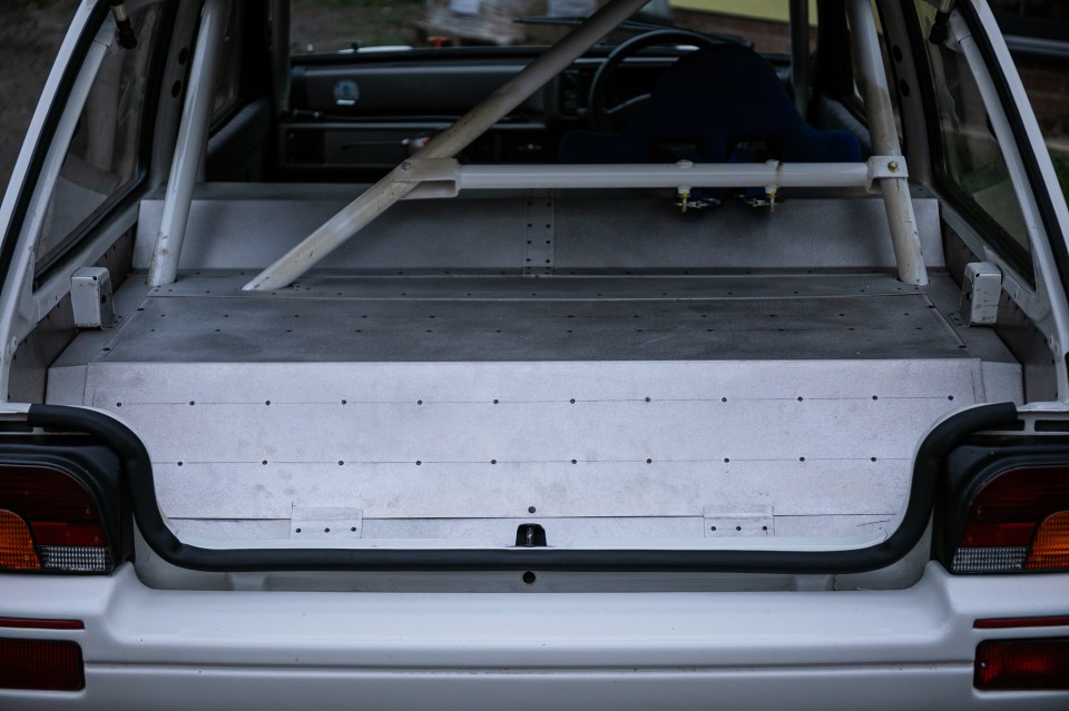 Rear view of a modified MG Metro GTI's trunk with aluminum paneling and roll cage.