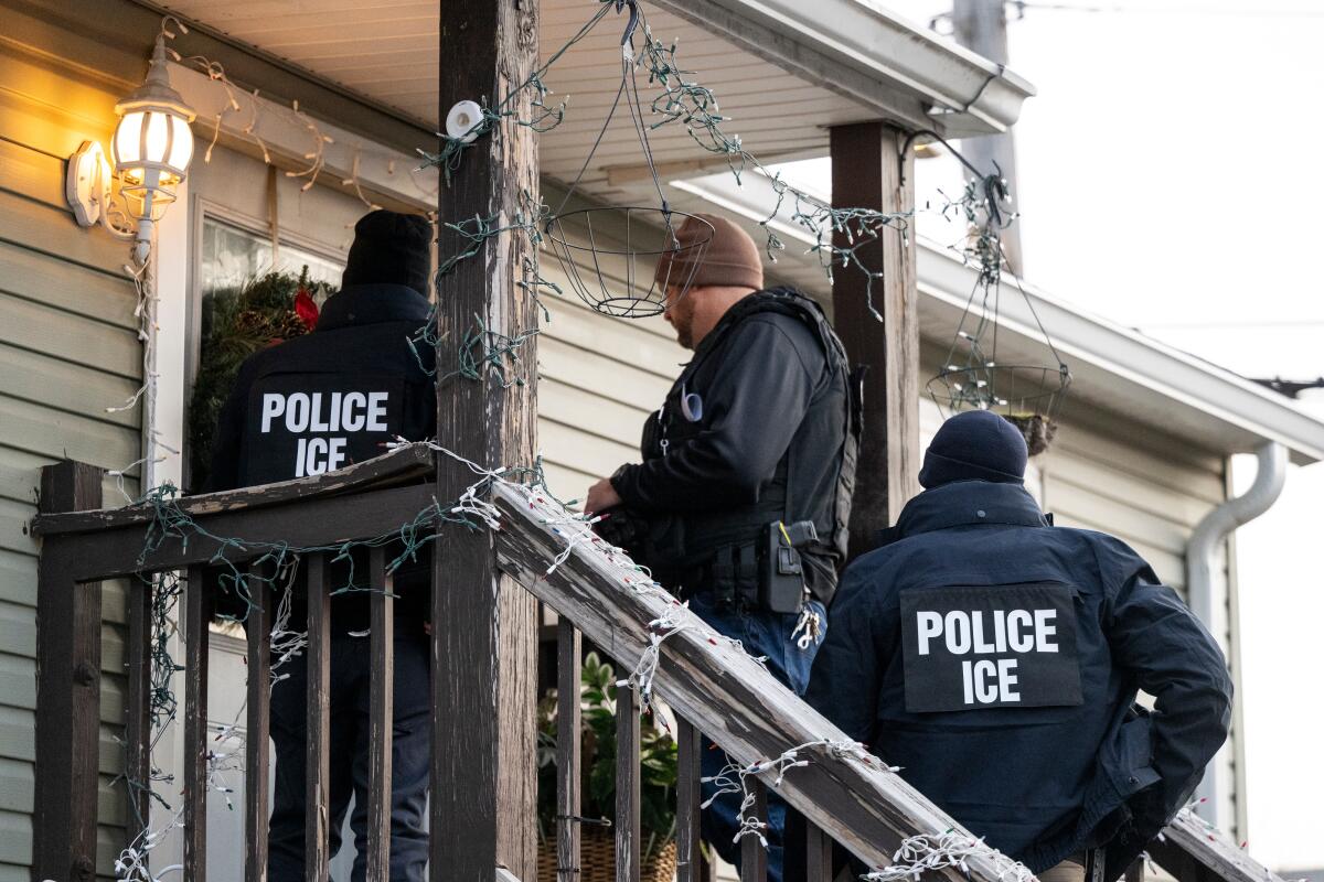 U.S. Immigration and Customs Enforcement agents knock on the door of a Chicago home.