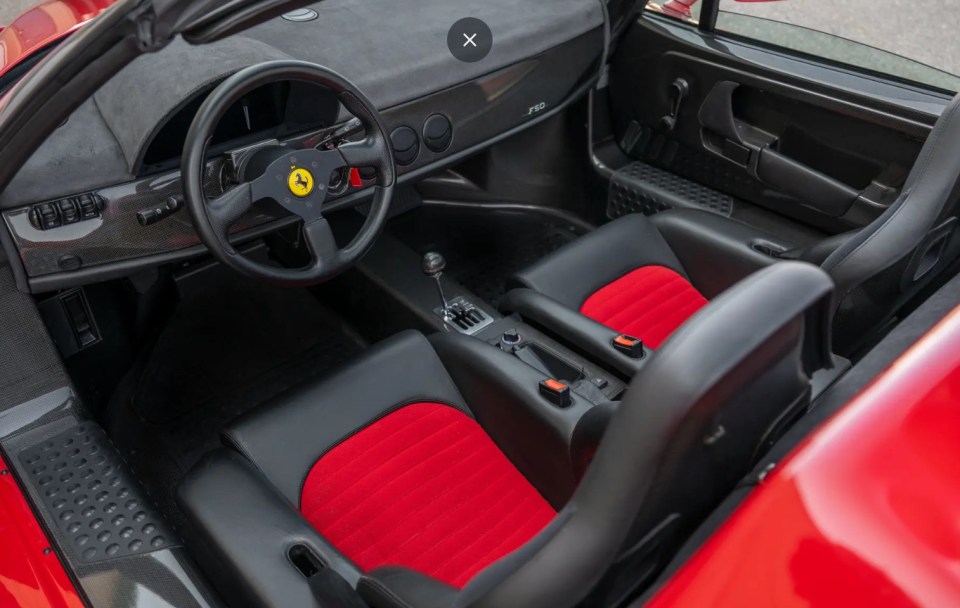 Red Ferrari F50 in a garage.