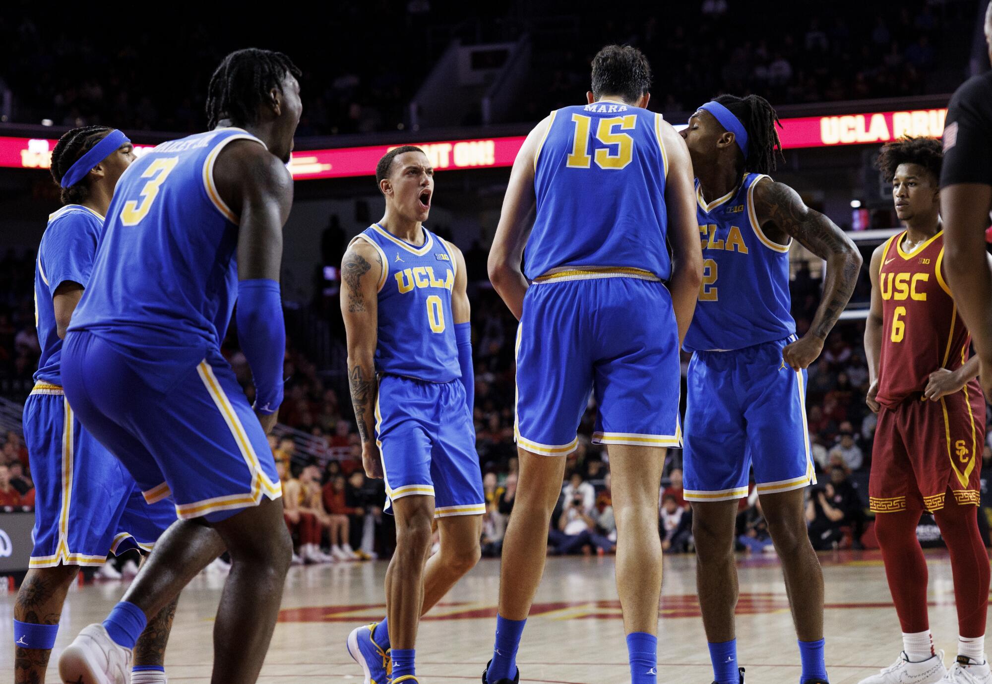 UCLA guards Eric Dailey Jr., Kobe Johnson and Dylan Andrews react while standing beside center Aday Mara 