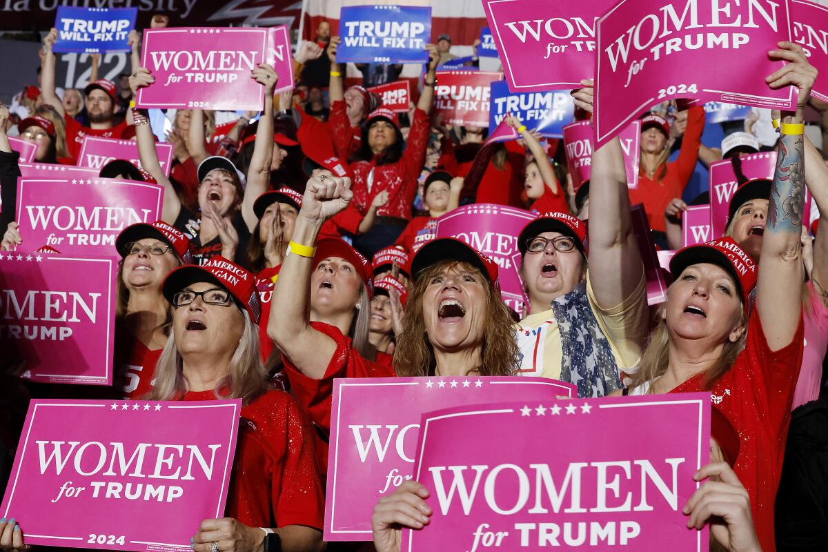 Supporters hold "Women for Trump" signs at a November campaign rally for Donald Trump.