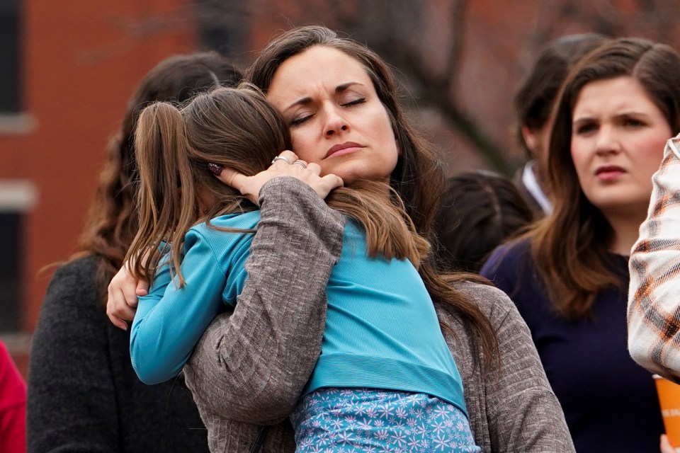 A woman comforting her daughter at a vigil.