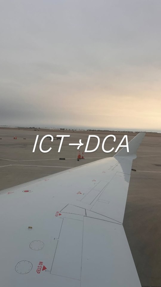 Airplane wing view from inside the plane, showing the tarmac and the text ICT→DCA.