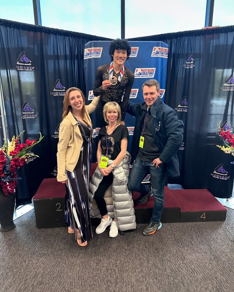 Spencer Lane on a podium with family after a figure skating competition.