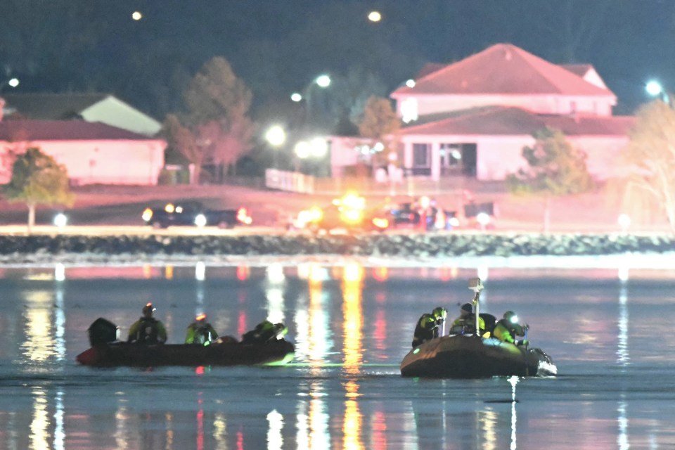 Rescue boats searching the Potomac River at night.