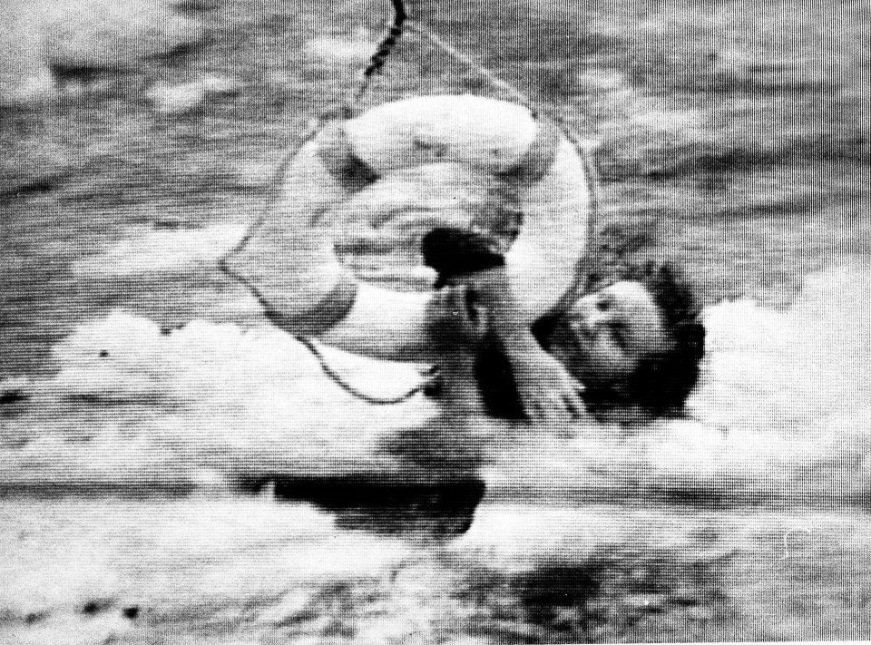 Grainy television image of a passenger holding a safety ring during a rescue.