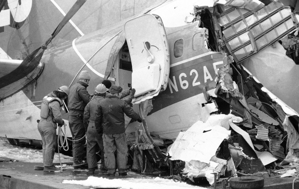 Workers examine the damaged tail section of an Air Florida jetliner after it was recovered from the Potomac River.