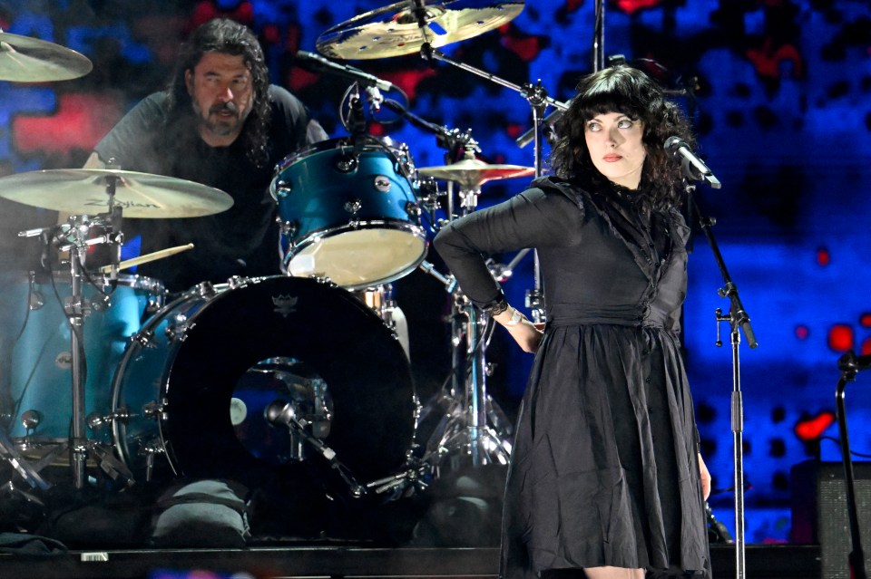 Violet Grohl performing onstage with a drummer.