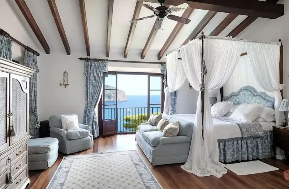 Bedroom with four-poster bed and ocean view.