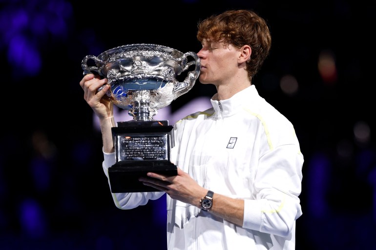 Italy's Jannik Sinner celebrates with the Norman Brookes Challenge Cup trophy after defeating Germany's Alexander Zverev during their men's singles final match on day fifteen of the Australian Open tennis tournament in Melbourne on January 26, 2025. (Photo by Martin KEEP / AFP) / -- IMAGE RESTRICTED TO EDITORIAL USE - STRICTLY NO COMMERCIAL USE --