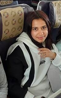 Woman sitting on a bus wearing a hoodie.