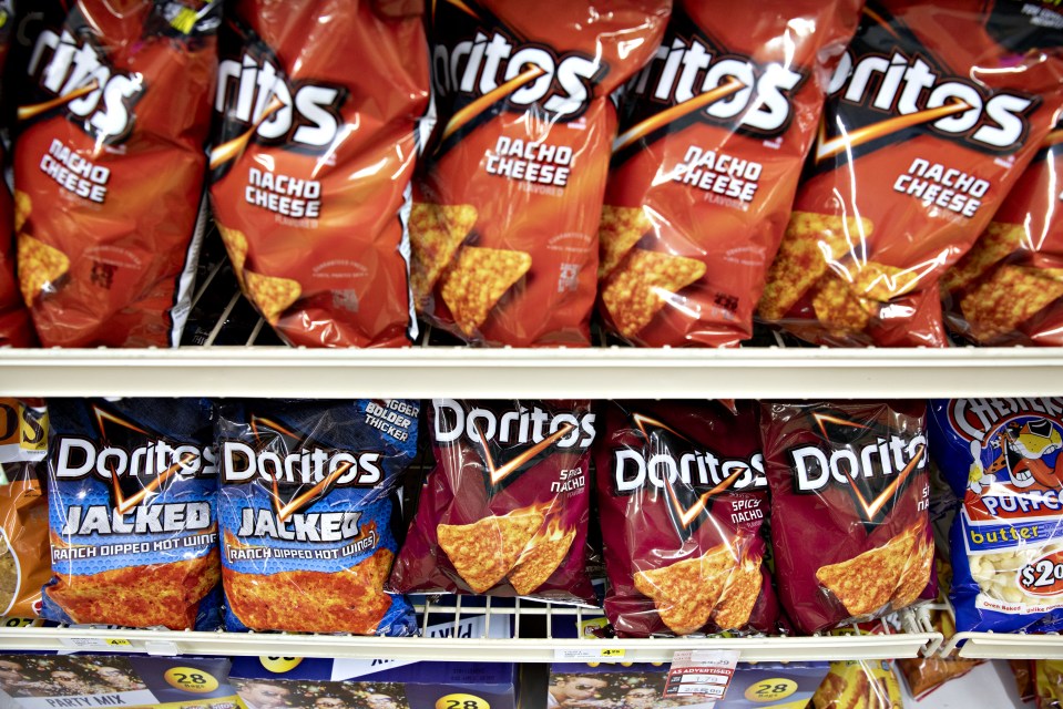 Bags of Doritos chips on a supermarket shelf.