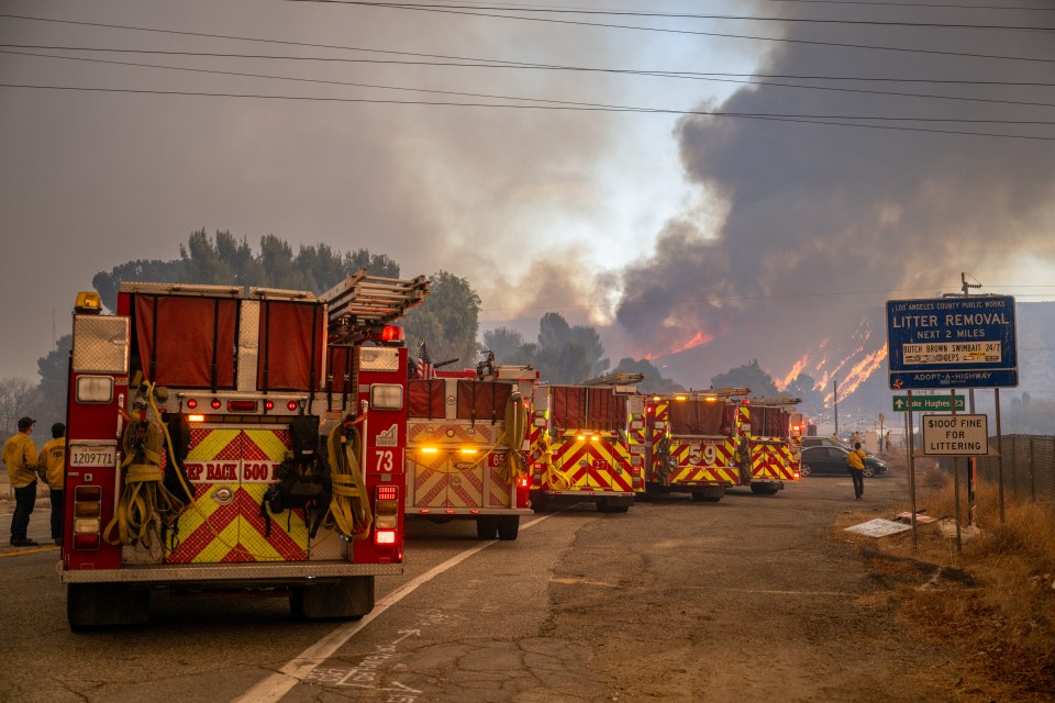 CASTAIC, CALIFORNIA - JANUARY 22: Firefighters station at the base of Lake Hughes road as the Hughes Fire burns in the distance on January 22, 2025 in Castaic, California. The wildfire is prompting mandatory evacuations just over two weeks after the Eaton and Palisades Fires caused widespread destruction across Los Angeles County. (Photo by Brandon Bell/Getty Images)