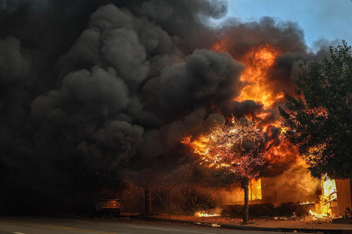 A business in Altadena is consumed by fire and clouds of black smoke.