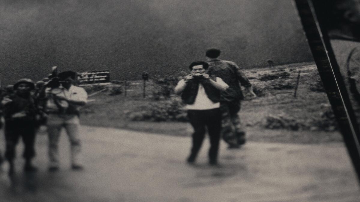 Photojournalists shoot images on a road.