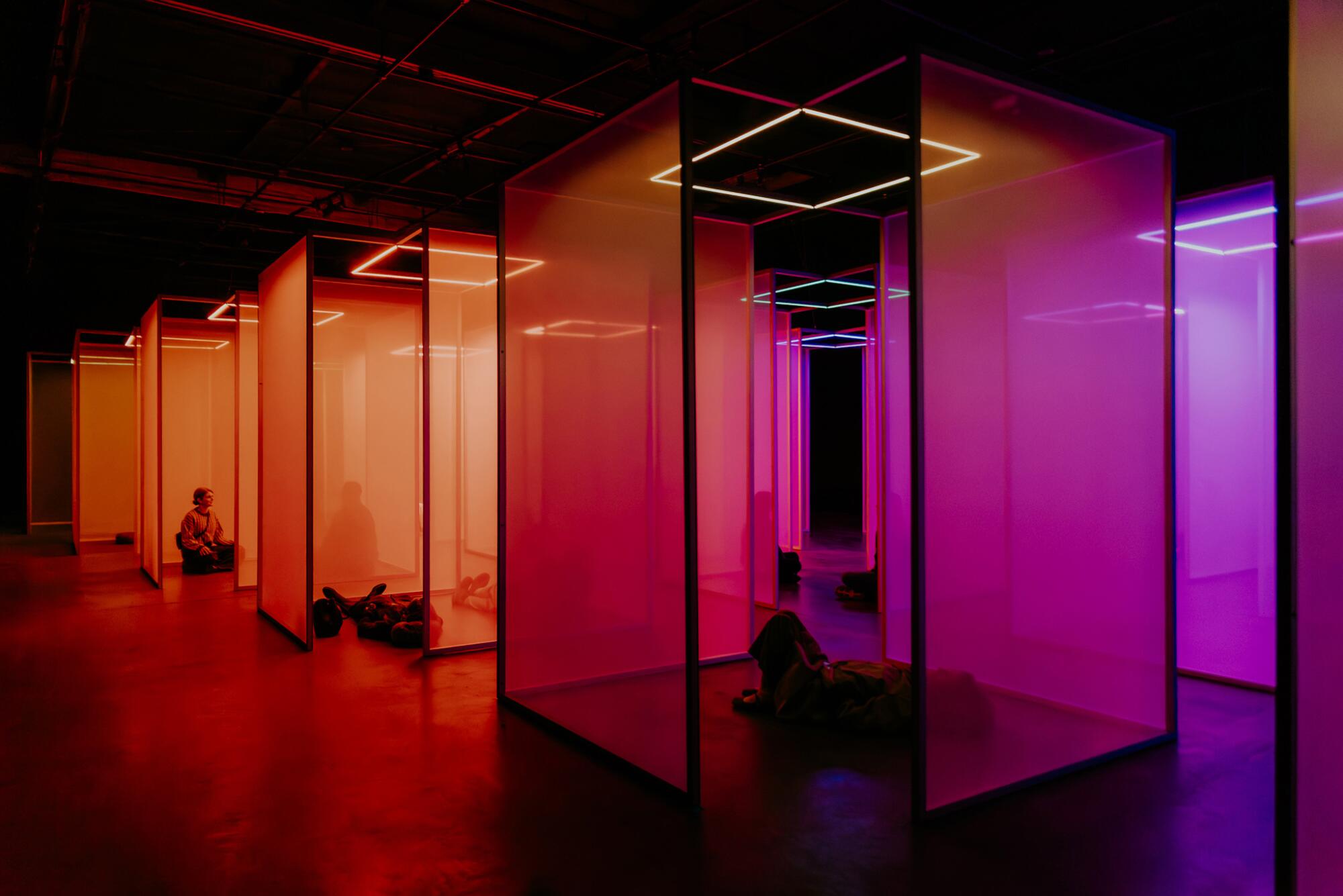 People relaxing amid translucent, boxy scrims. 