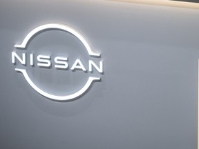 A staff member stands next to the Nissan logo in the showroom at Nissan's global headquarters in Yokohama, Kanagawa prefecture on Feb.10, 2025.